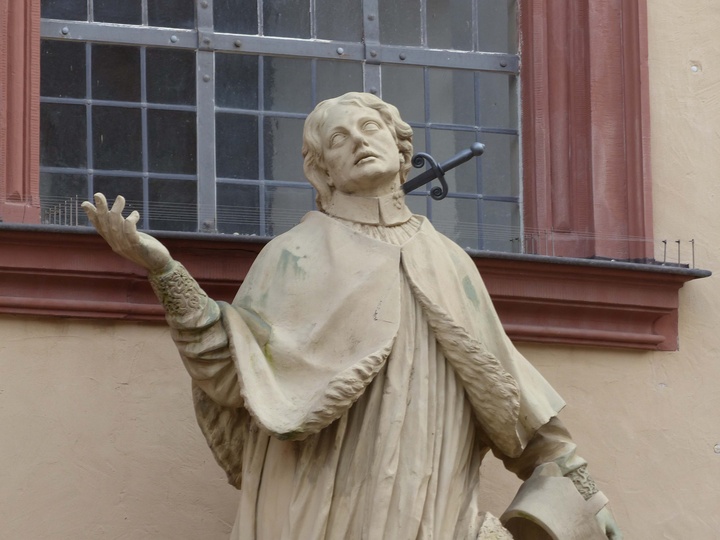 Eine Statue des heiligen Aquilins vor der Pfarrkirche St. Peter und Paul in Würzburg.
