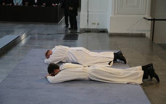Zwei angehende Priester liegen bei ihrer Weihe auf dem Boden.