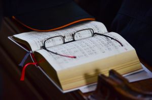Das Gotteslob liegt bei einem Familiengottesdienst am 6. April 2015 in Fulda aufgeschlagen auf der Kirchenbank. Eine Brille liegt darauf.