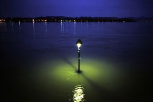 Hochwasser im Januar 2003 in Bonn. Gespenstisch leuchten die im Wasser stehenden Laternen der Rheinpromenade.