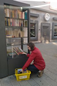 Anne Große-Schulte, Leiterin der Würzburger Liborius-Wagner-Bücherei, stellt einen Teil der Bücher, die sonst beim jährlichen Flohmarkt verkauft werden, in den öffentlichen Bücherschrank in der Eichhornstraße ein. 
