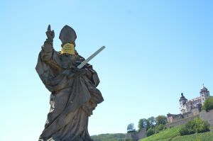 "Wir halten seit 295 Jahren Abstand!": Auch der heilige Kilian auf der Alten Mainbrücke trägt vorübergehend einen Mund-Nasen-Schutz.