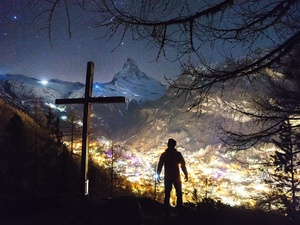 Mann an einem Kreuz bei Nacht