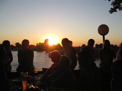 Menschen am Fluss beim Sonnenuntergang.