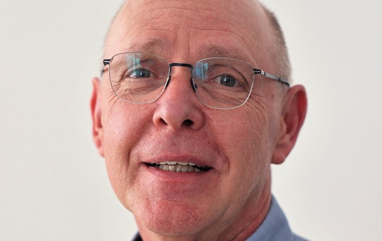 Ein Mann mit Brille schaut in die Kamera