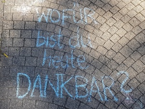 "Wofür bist du heute dankbar?" mit Kreide auf eine Straße geschrieben