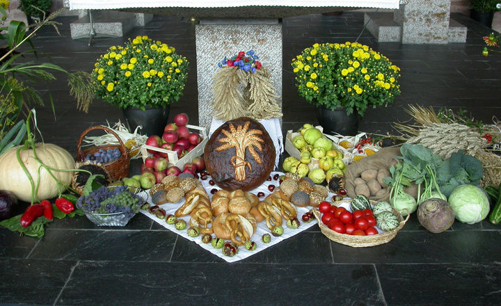 Zu Erntedank liegen vor einem Altar Gaben wie Obst, Gemüse, Blumen und Brot.