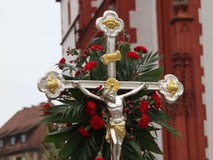 Zum Palmsonntag ist das Kreuz mit Palmzweigen und Blumen geschmückt.