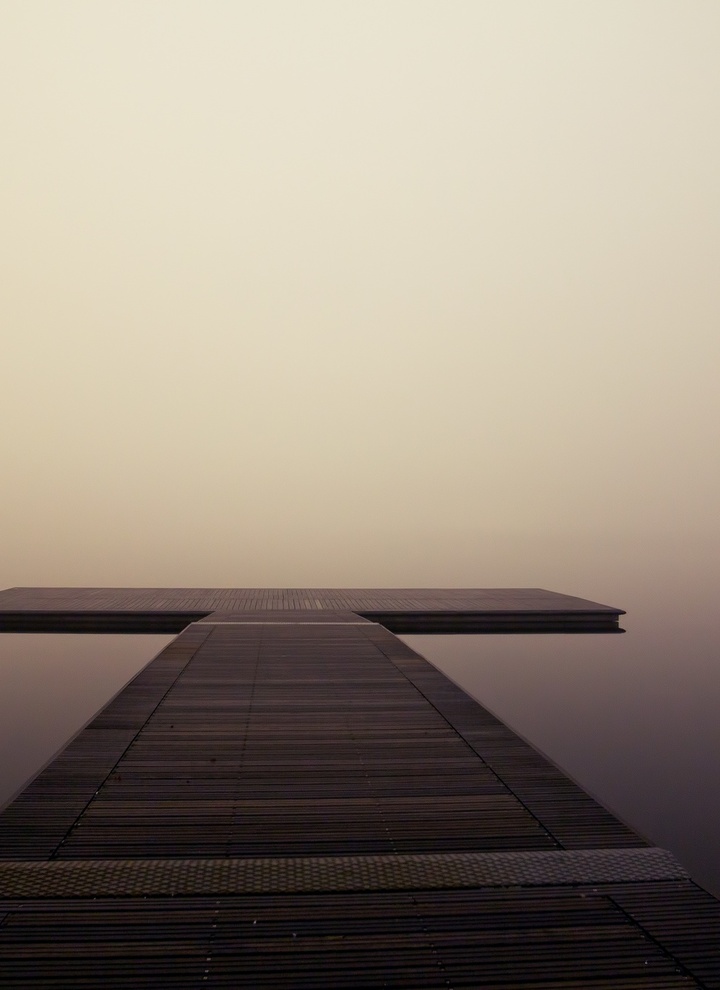 Ein Steg in Kreuzform im Nebel.