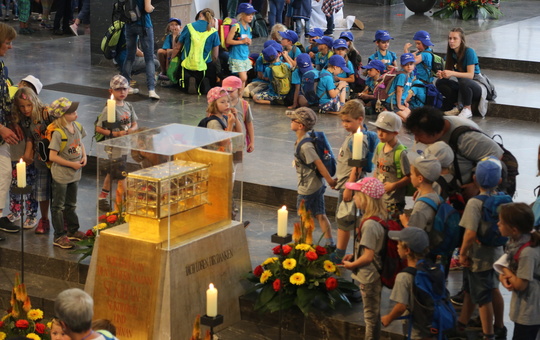 Kinder stehen zur Kilianiwallfahrt um den Schrein mit den Häuptern der Frankenapostel.